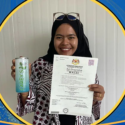 A member of the Ladang YS team holding a halal certificate and a canned drink